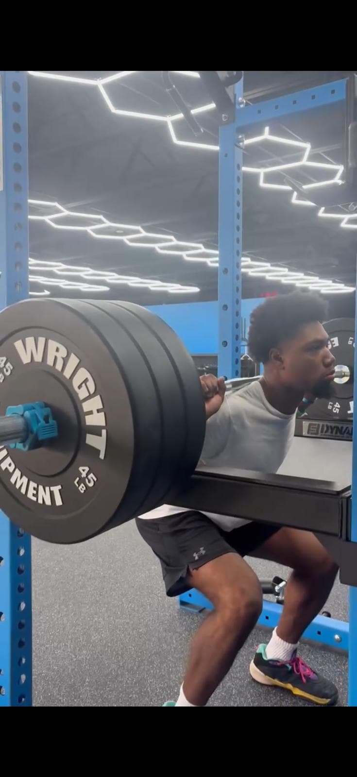 Athlete performing a loaded squat at Phyx Performance
